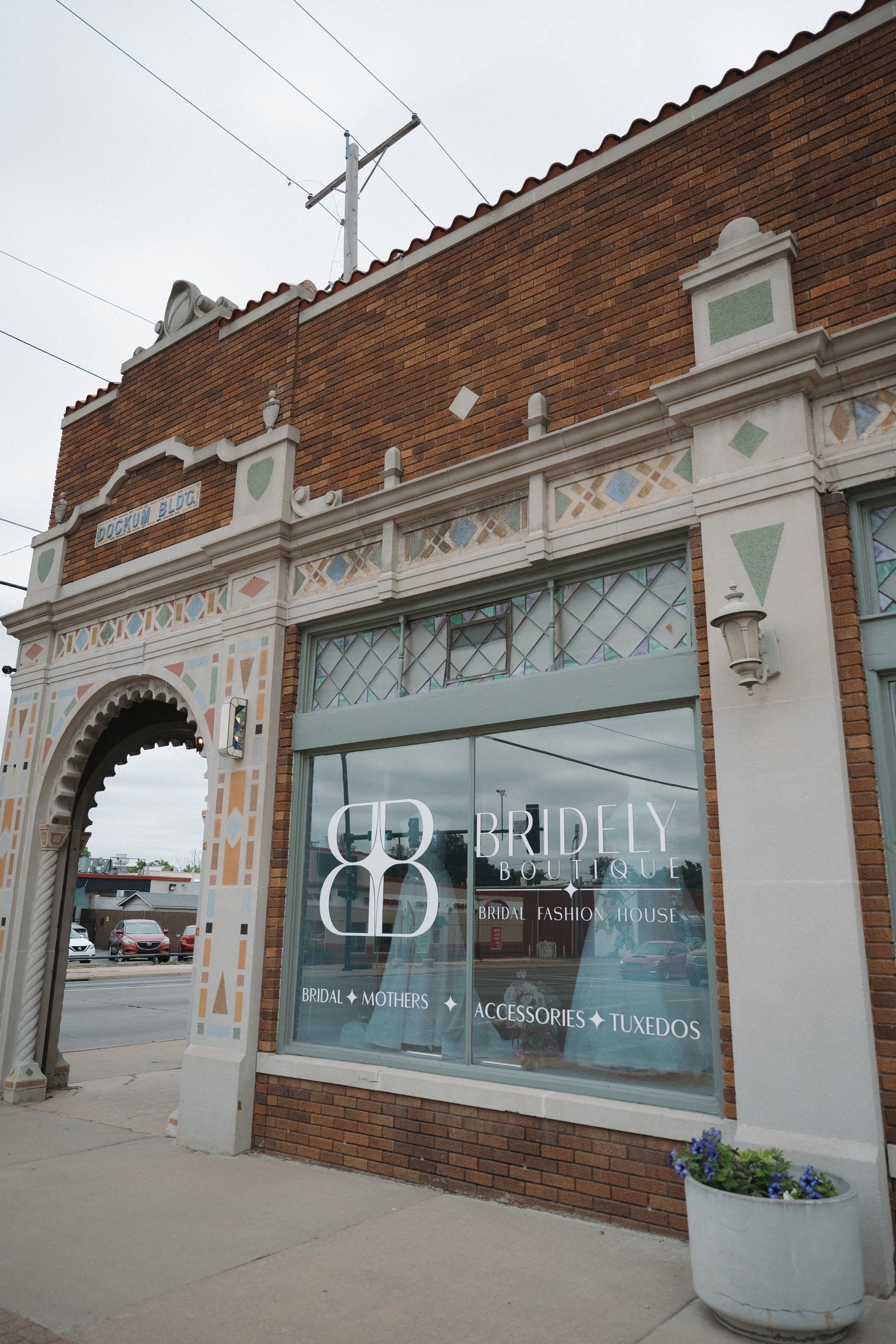 Brinley Bridal storefront: brick building with large windows, floral accents, and a potted plant.