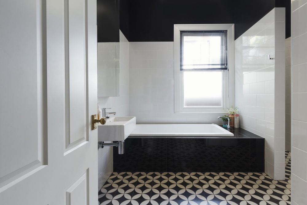 A Bathroom With A Pattern Tiles, Bathtub, Sink, Mirror And Window — Instyle Kitchens & Coatings in Ballina, NSW