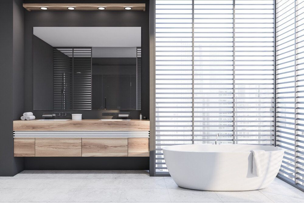 A Bathroom with A Tub , Sink , Mirror and Blinds — Instyle Kitchens & Coatings in Lismore, NSW