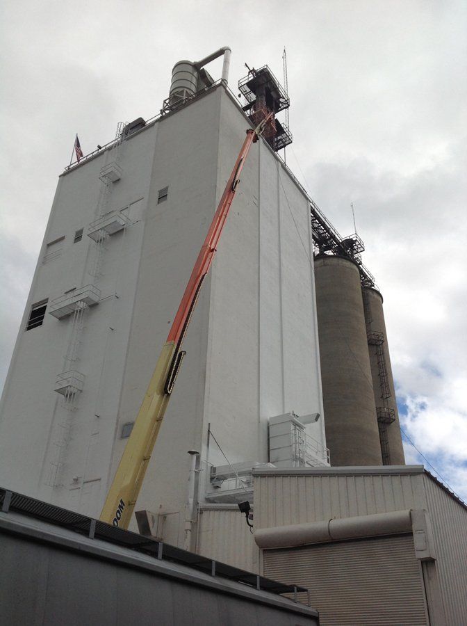 A large white building with a crane on top of it.