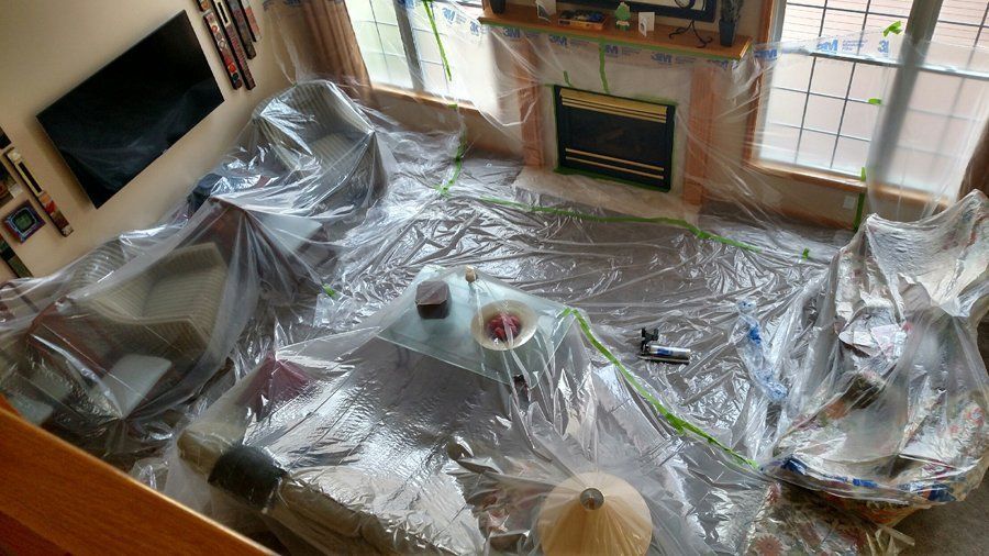 An aerial view of a living room covered in plastic.