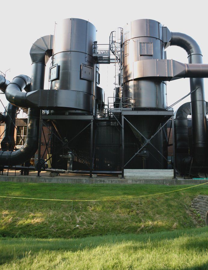 A large industrial building with a lot of pipes coming out of it