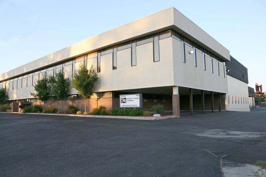 A large building with a lot of windows and a parking lot in front of it