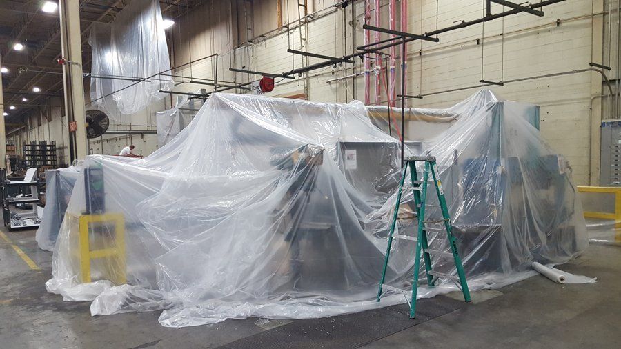 A machine is covered in plastic in a factory.