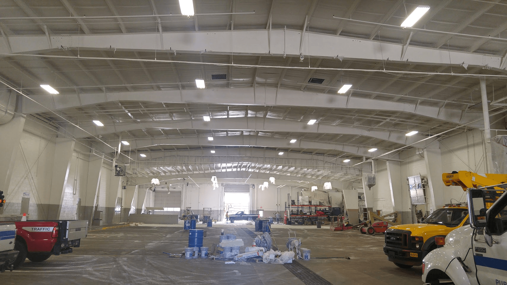 A large warehouse with trucks parked inside of it