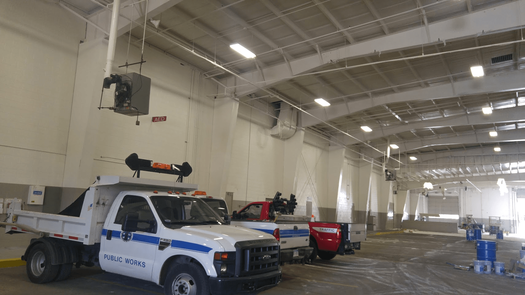 Two trucks are parked in a large warehouse.