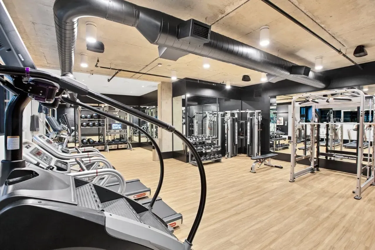 A gym filled with lots of exercise equipment and a treadmill.