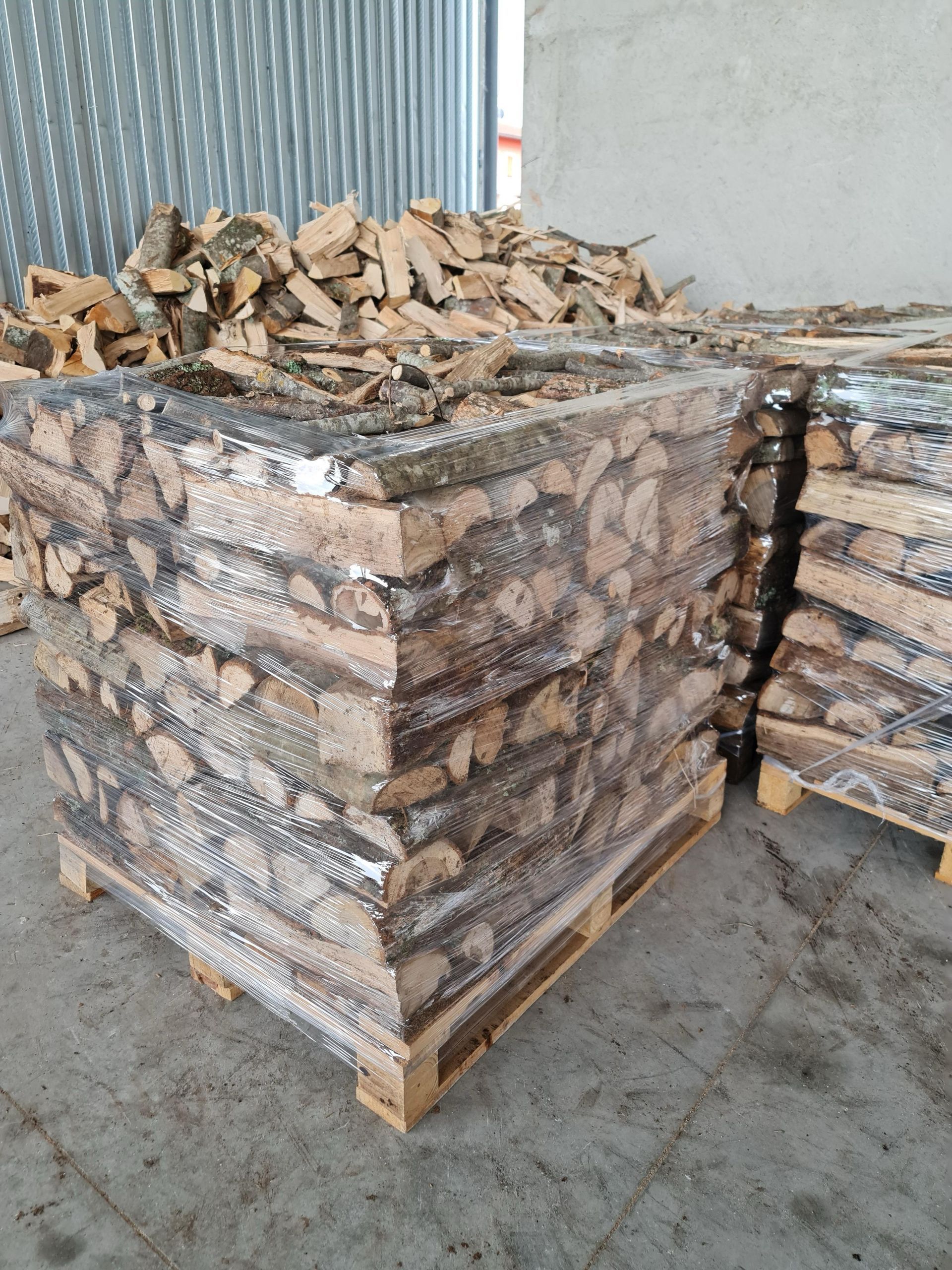 Una catasta di legna è posta sopra un pallet di legno.