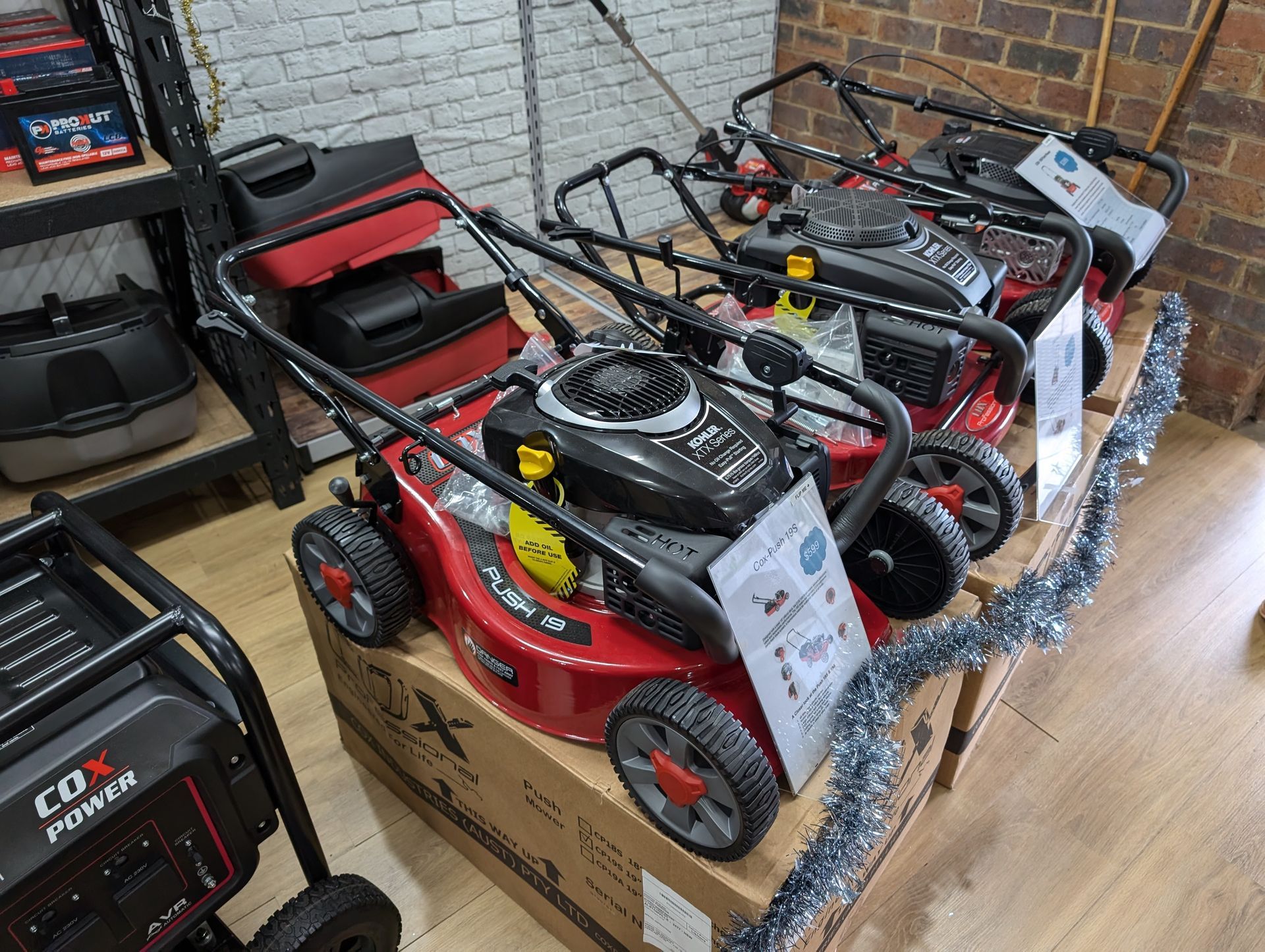 A Row Of Lawn Mowers Sitting On Top Of Boxes In A Store — Plateau Mower Repairs In Alstonville, NSW