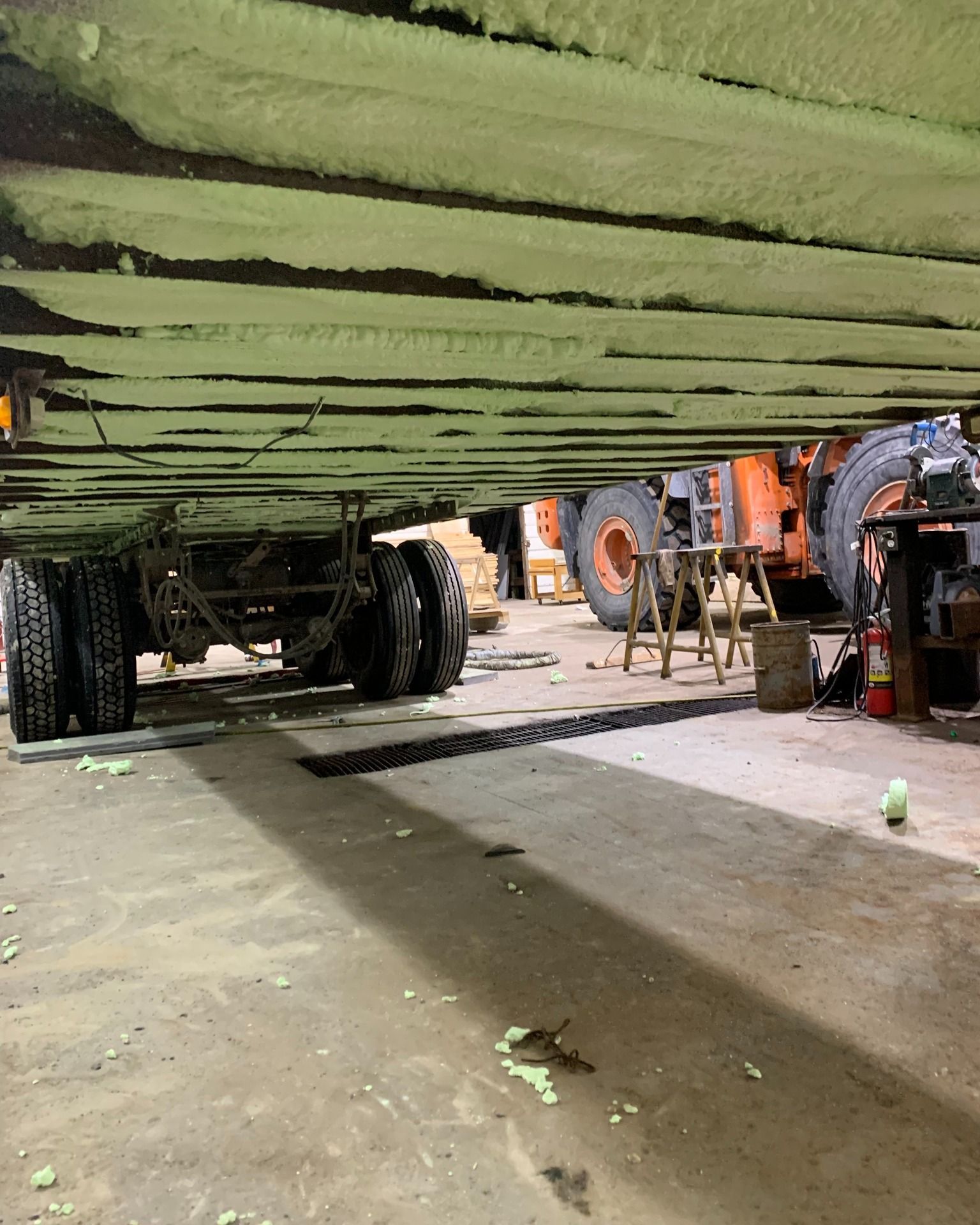 a row of trucks are parked under a bridge in a garage .