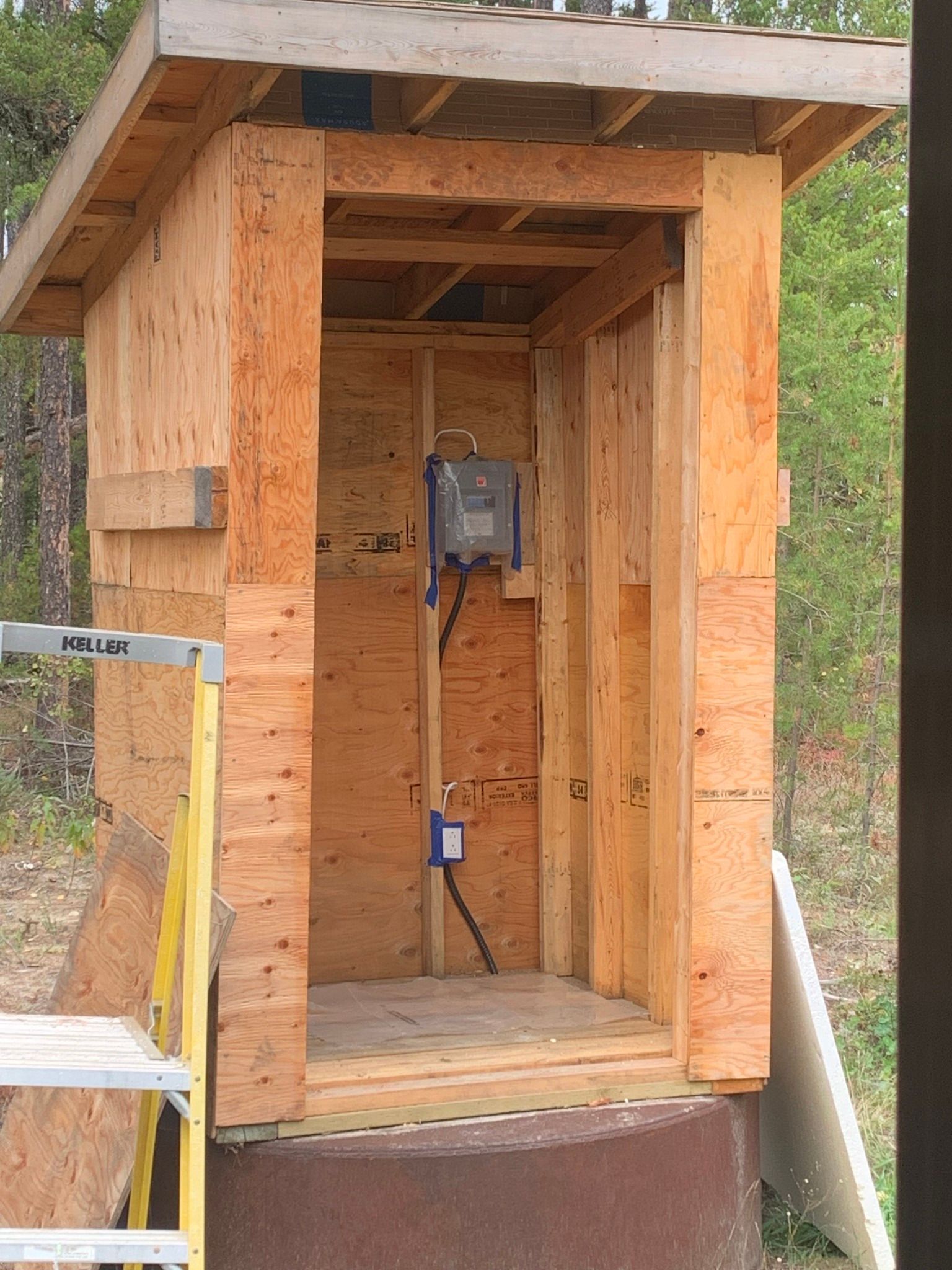 a small wooden shed with a ladder in front of it