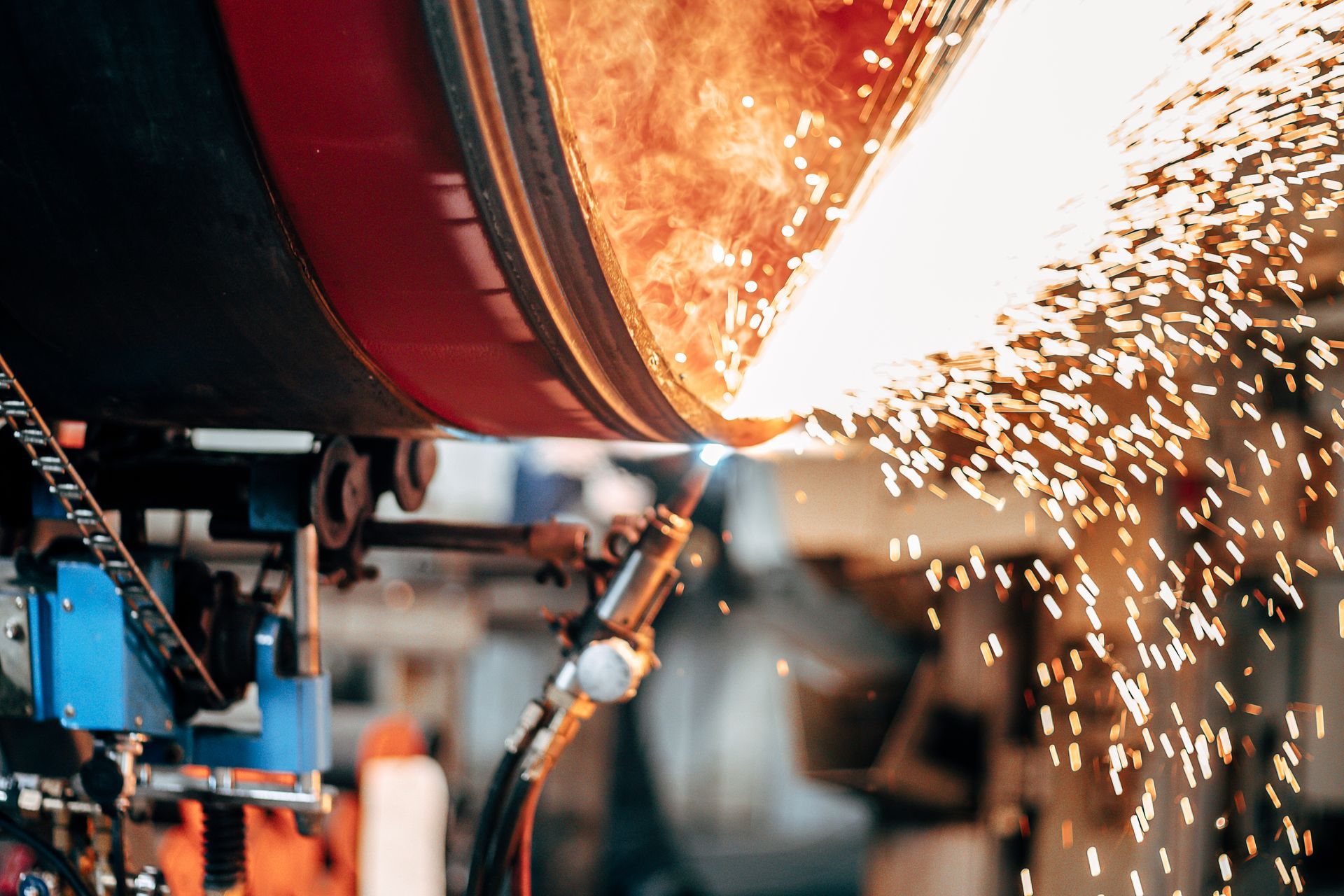 A machine is cutting a metal pipe in a factory.