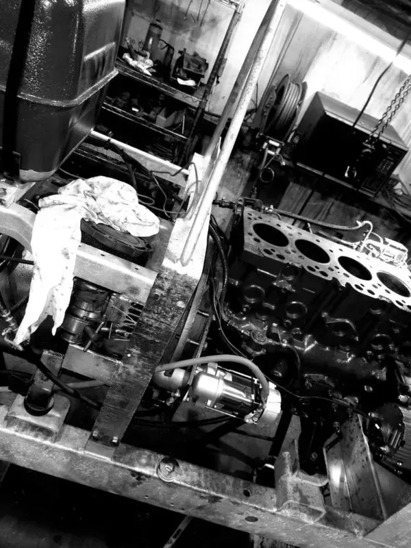 A black and white photo of a car engine being worked on