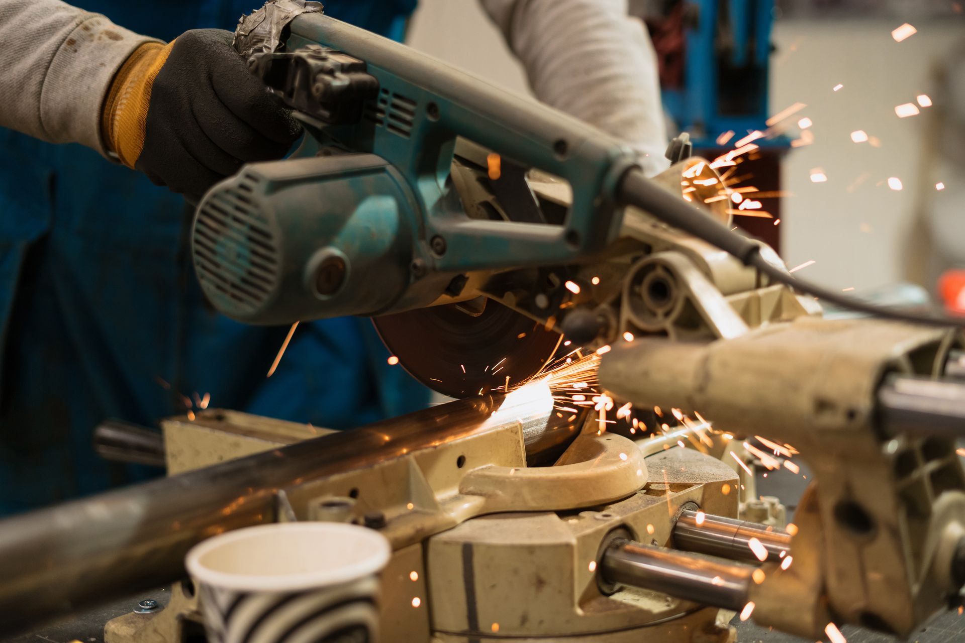 A person is using a circular saw to cut a piece of metal.