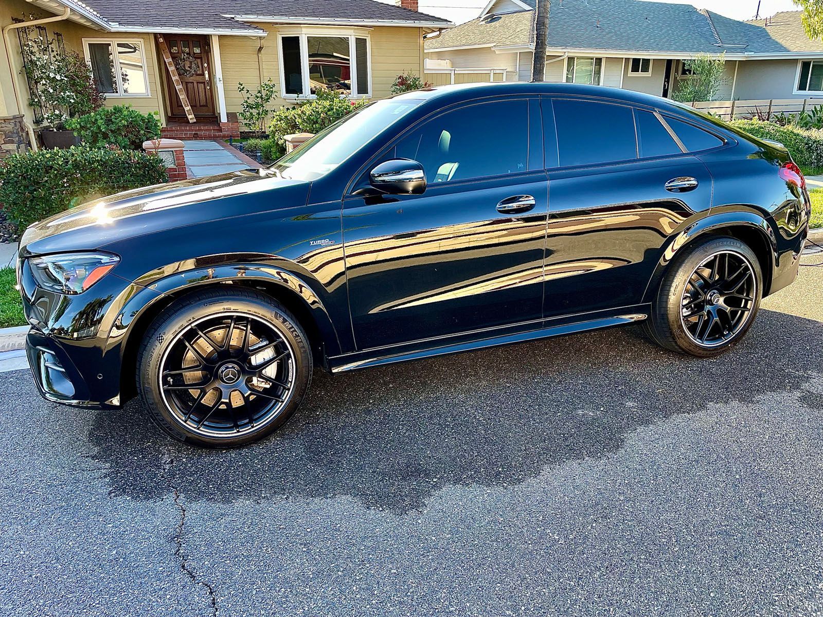 Dark gray sports car, side view, illuminated headlights and taillights against a black background.