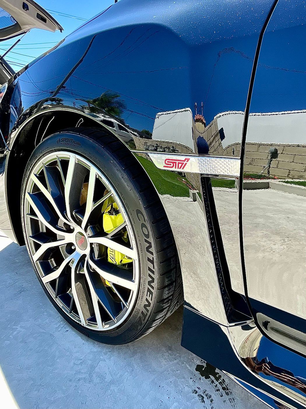 Black luxury cars parked in a line, focus on the front headlight and wheel.