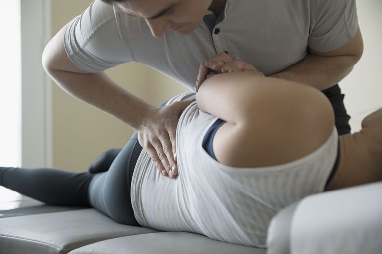 A man is giving a woman a massage on a couch.