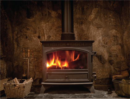 A small black multifuel stove is sitting in a fireplace.