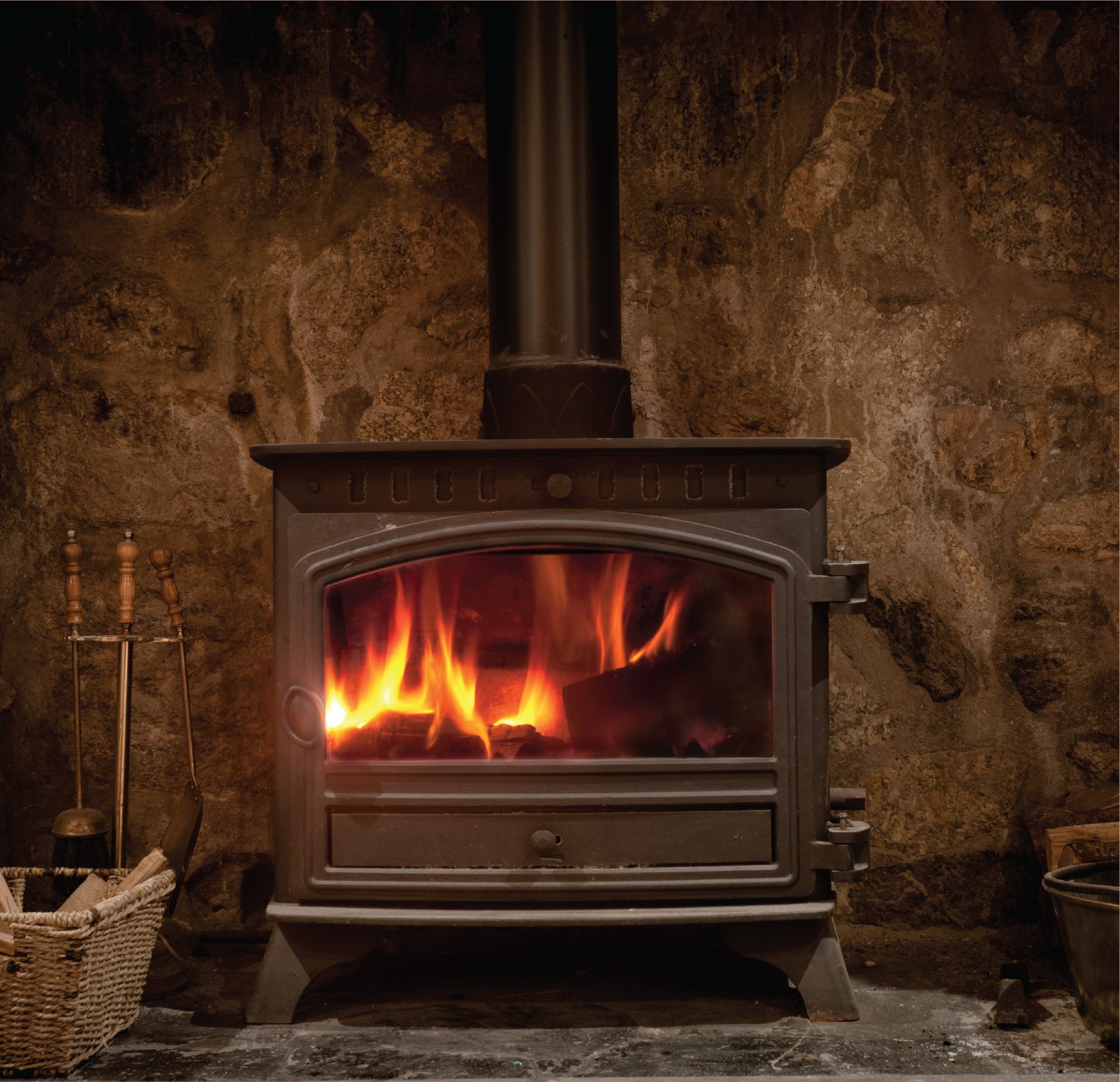 A small black stove is sitting in a fireplace