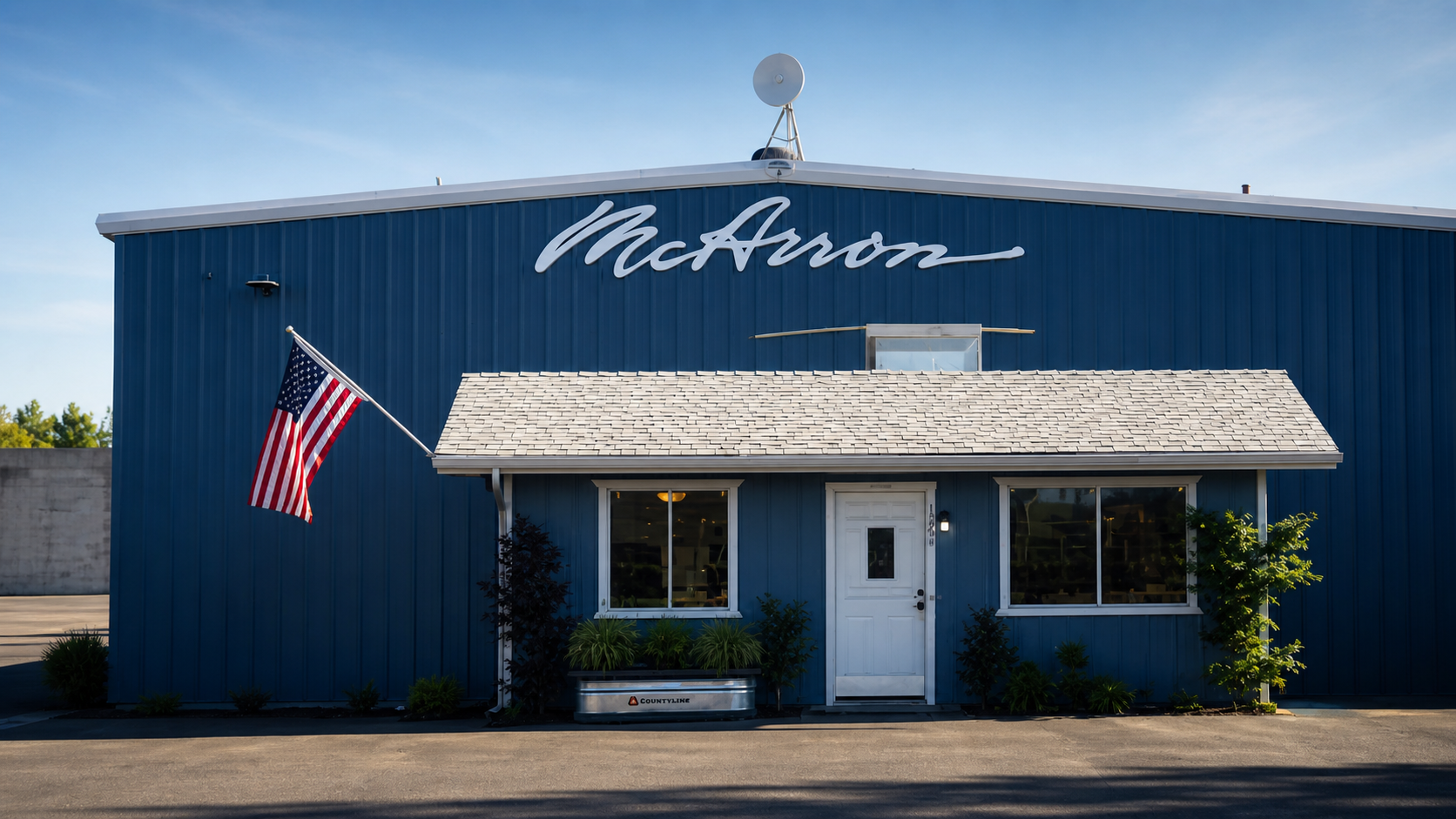 Blue McAnors building with an American flag and white front porch under a clear sky