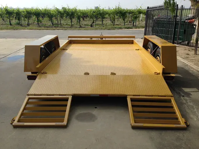 Yellow wheelchair accessibility platform with side guards and front ramps on pavement outdoors