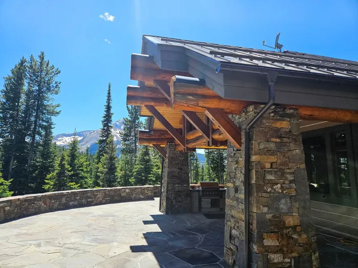 Professional technician inspecting gutters on Boulder home with mountains in background