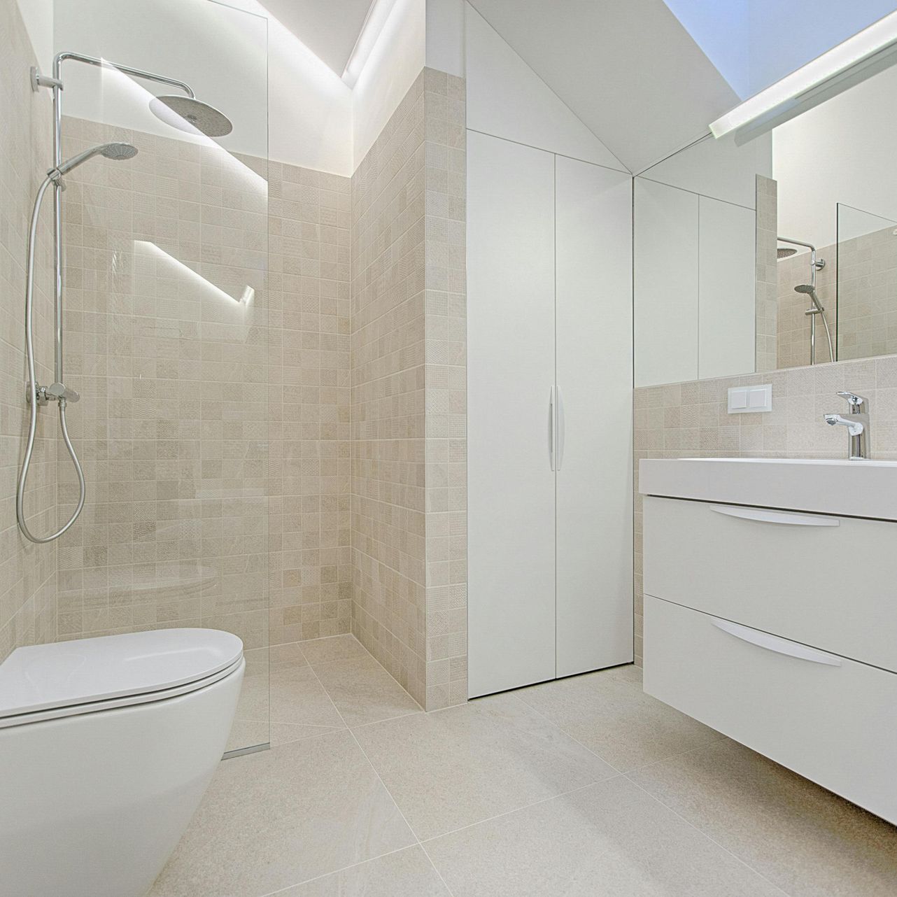 Modern bathroom with a walk-in shower, toilet, and vanity in neutral tones.