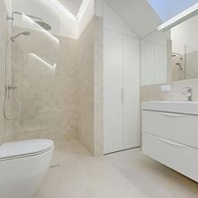 Modern bathroom with a walk-in shower, toilet, and vanity in neutral tones.