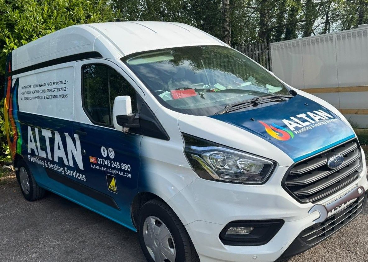 White Ford van with blue and orange ALTAN logo, parked outside.