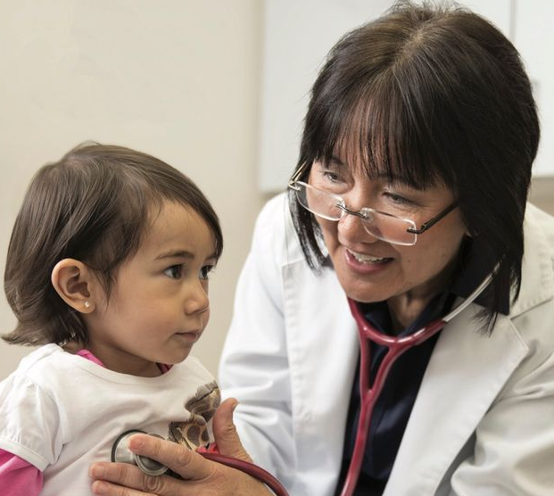 A doctor is listening to a baby 's heartbeat with a stethoscope