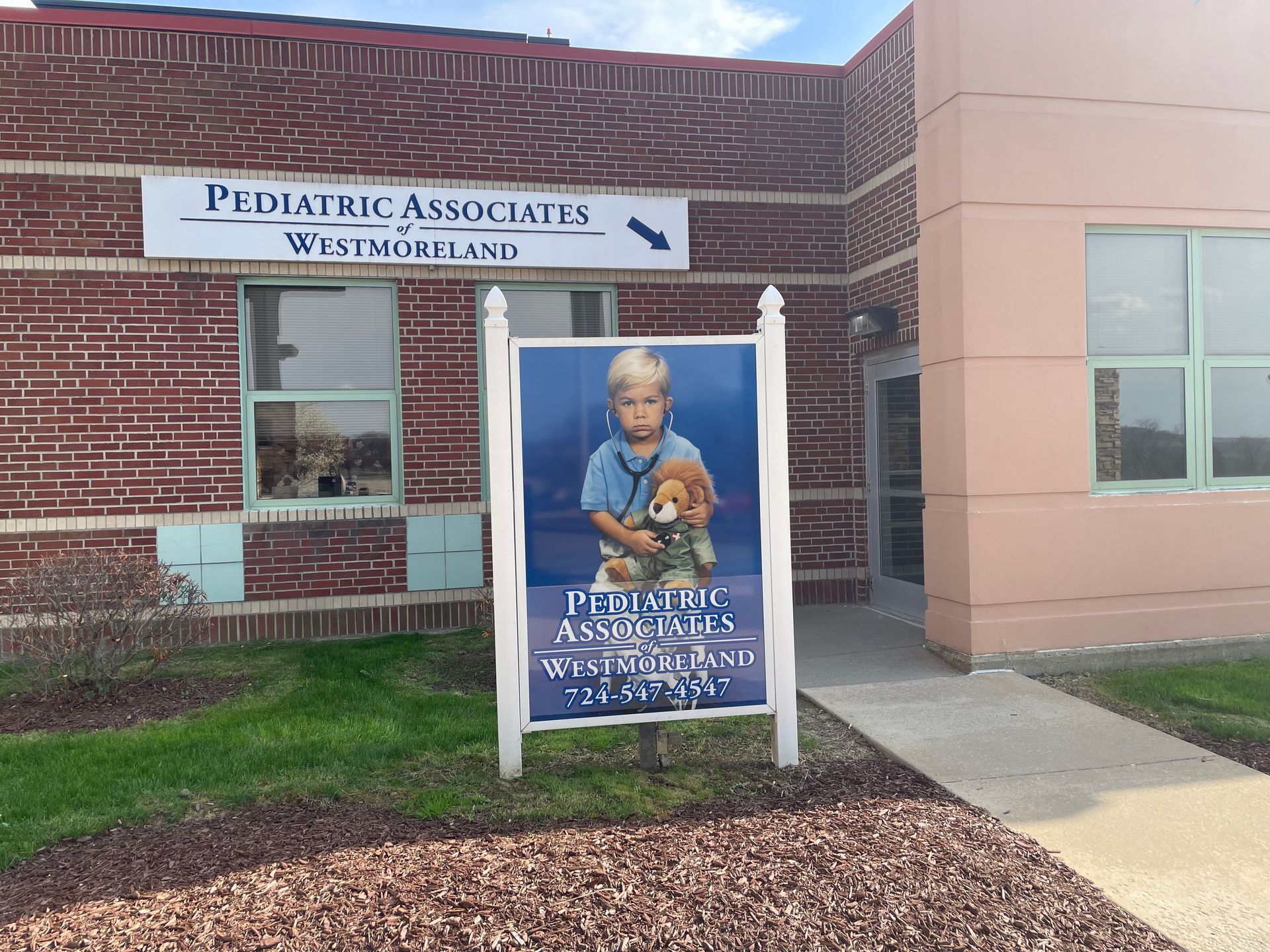 A pediatric associates building with a sign in front of it