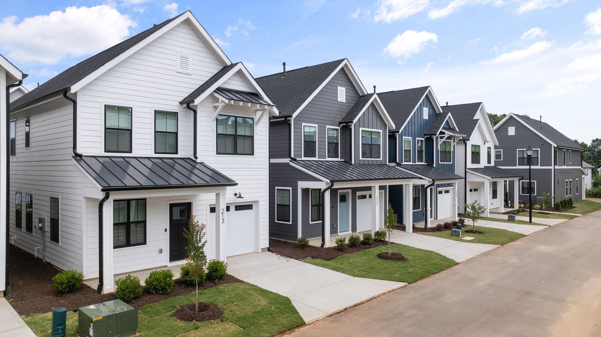 A row of black and white houses on a residential street.