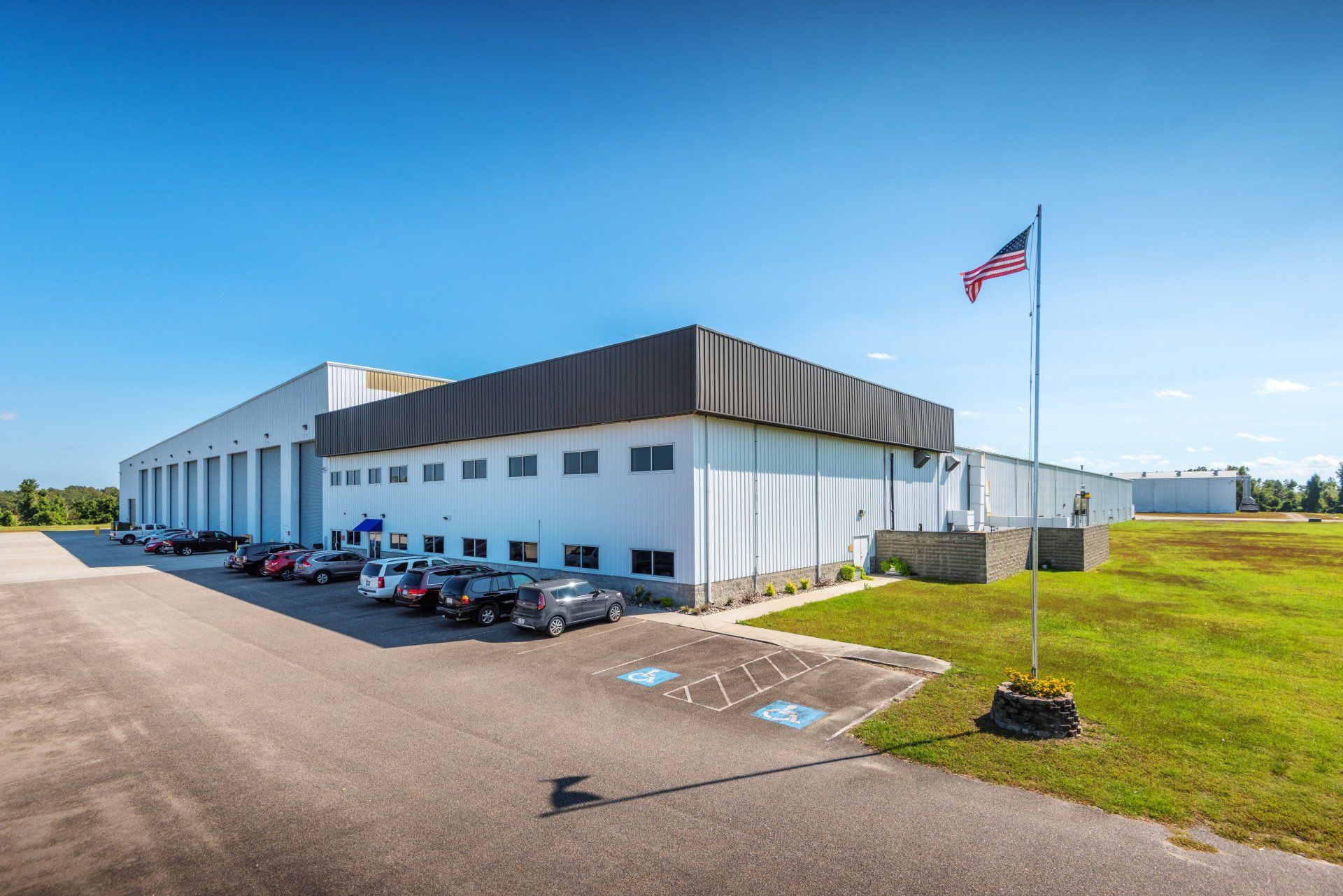 A large white building with a lot of cars parked in front of it.