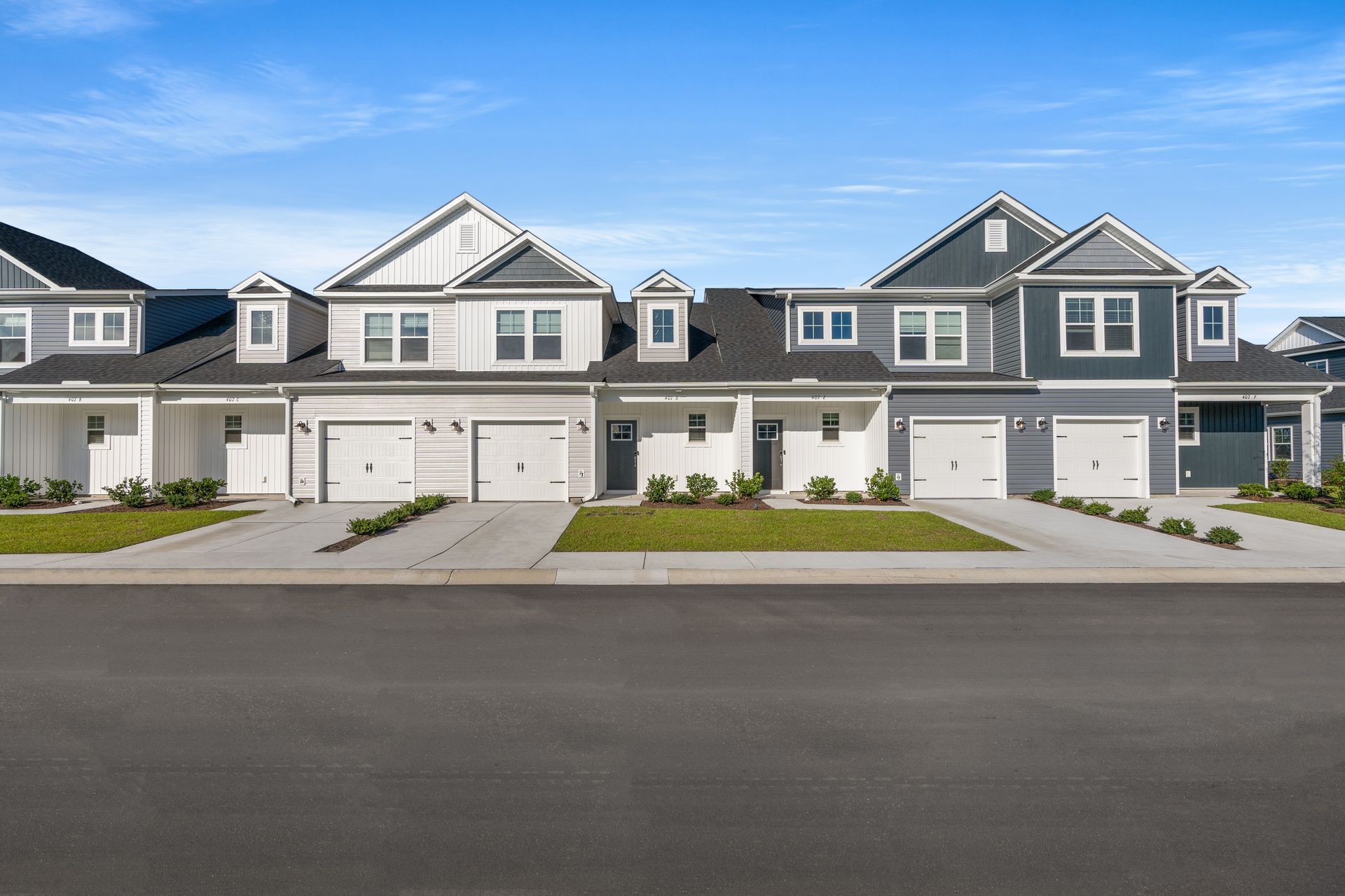 A kitchen and dining room in a house with hardwood floors and white cabinets.