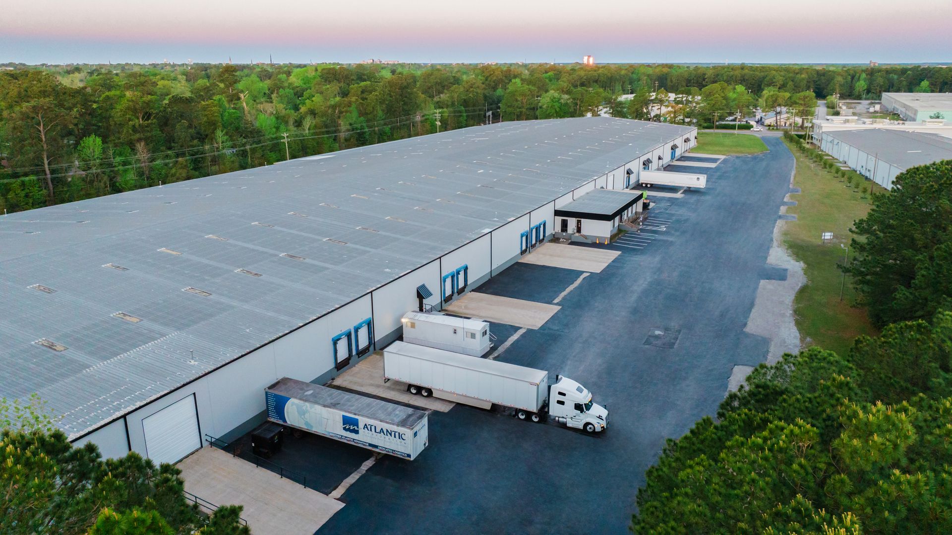 An aerial view of a warehouse with trucks parked in front of it.