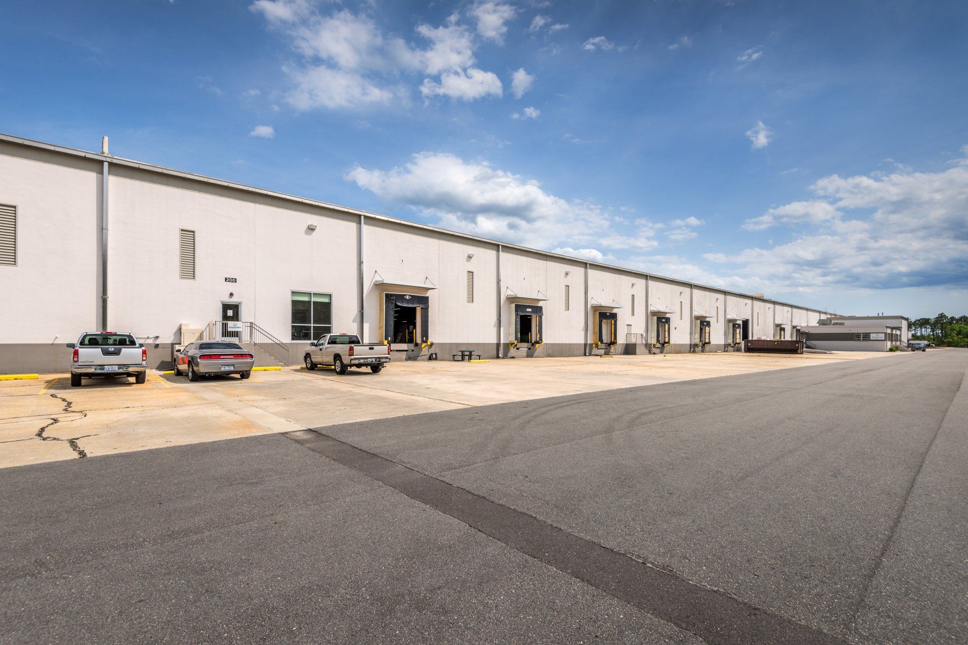 A large warehouse with trucks parked in front of it.