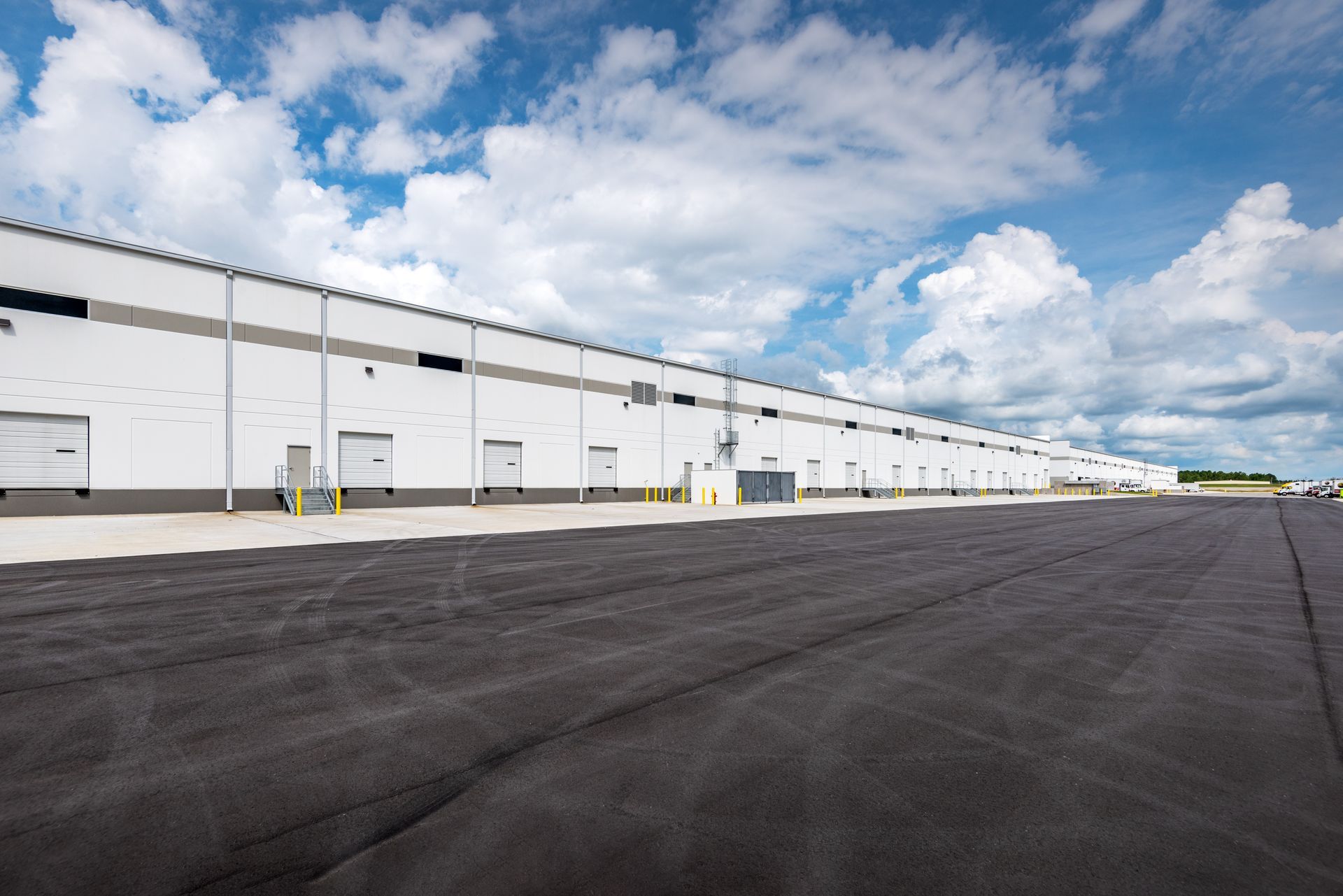 A large white building with a lot of doors and a runway in front of it.