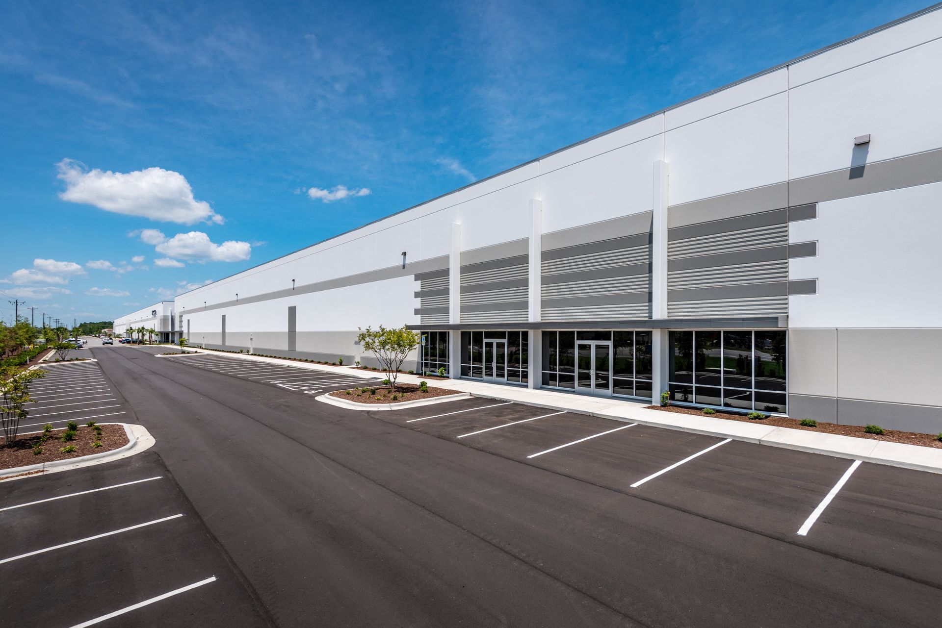 A large white building with a parking lot in front of it.