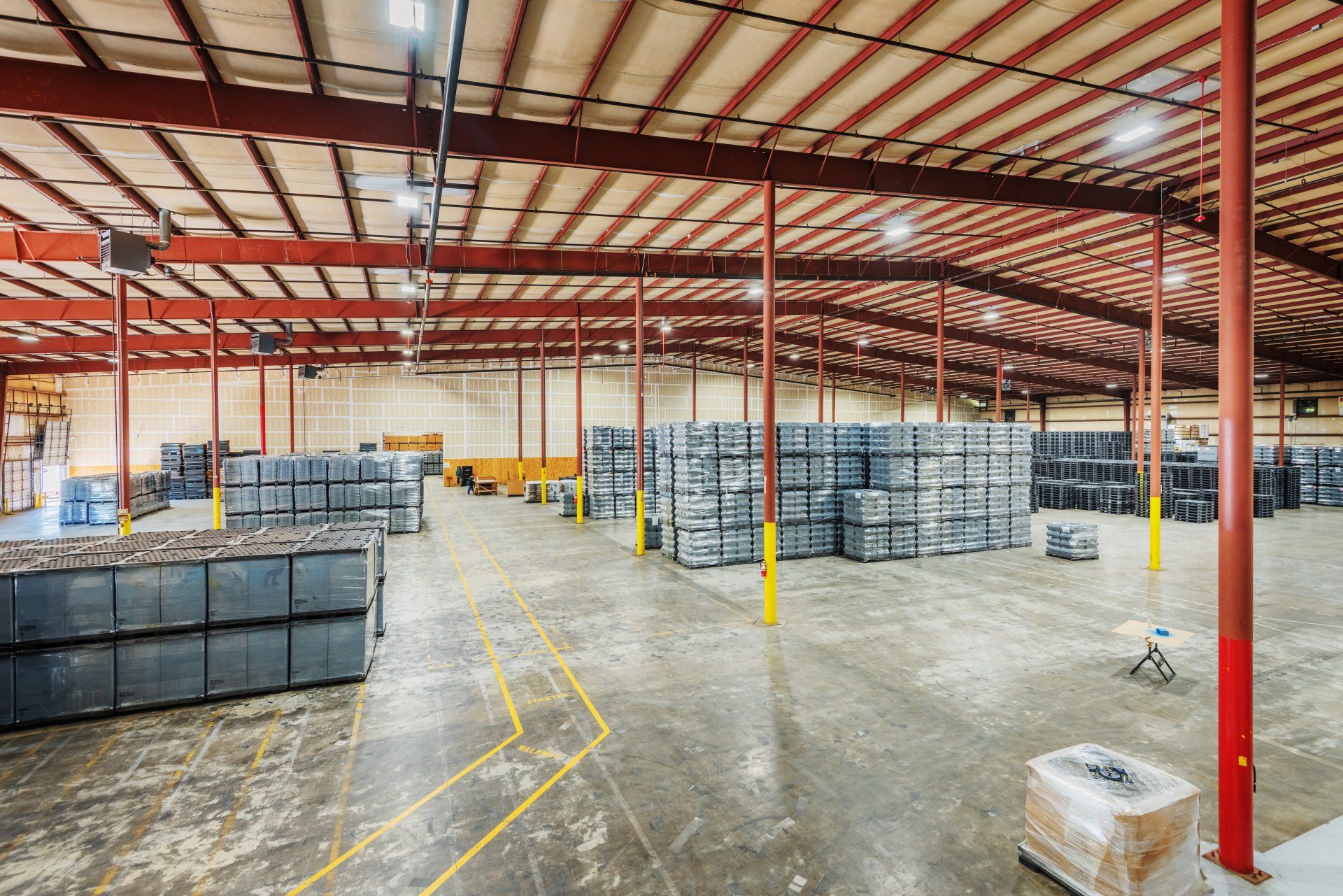 A large warehouse filled with lots of pallets and boxes.