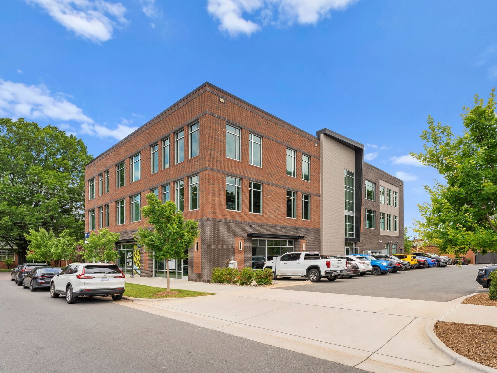 Looking up at a tall glass building with a blue sky in the background.