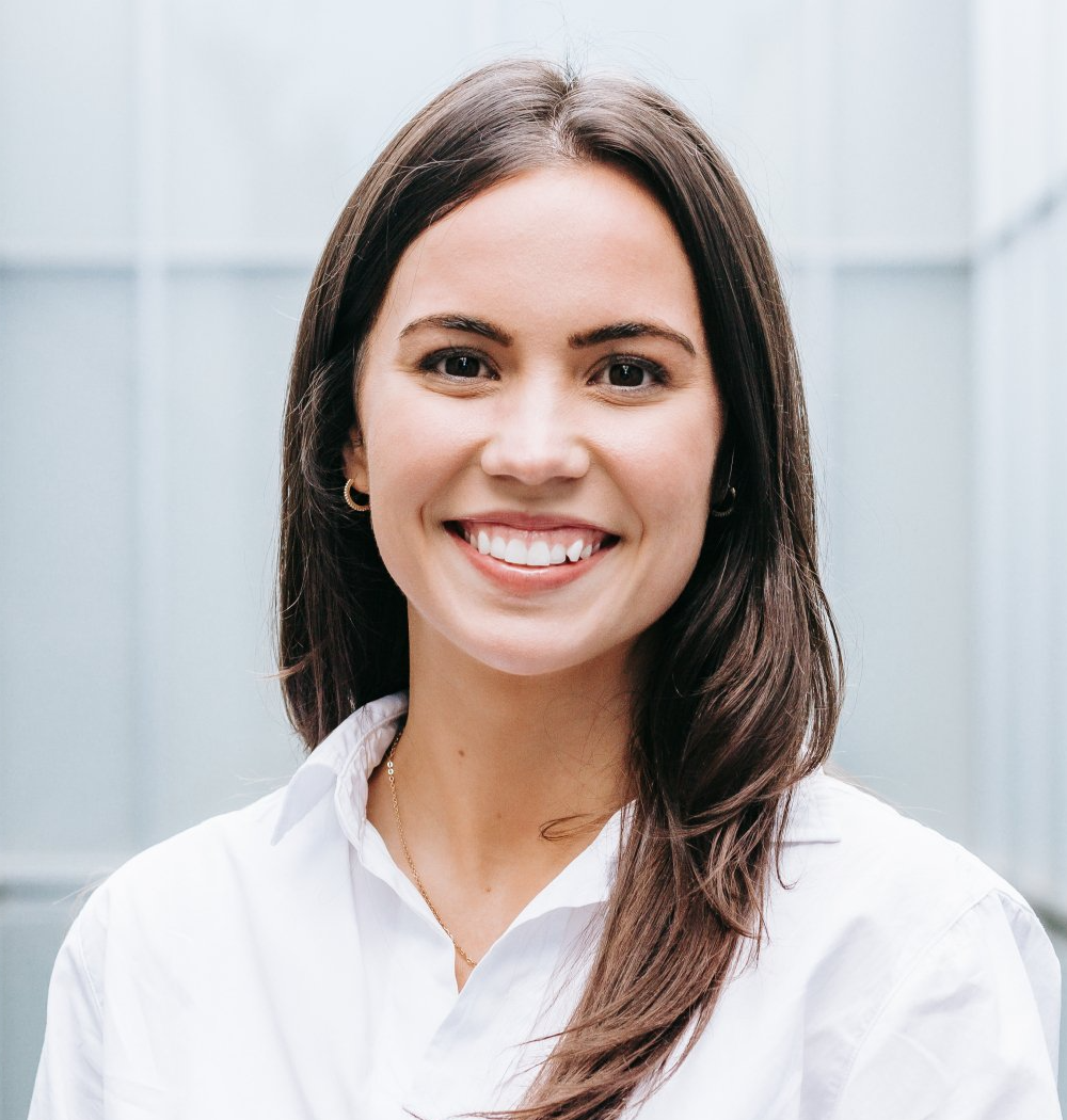 A woman in a white shirt is smiling for the camera