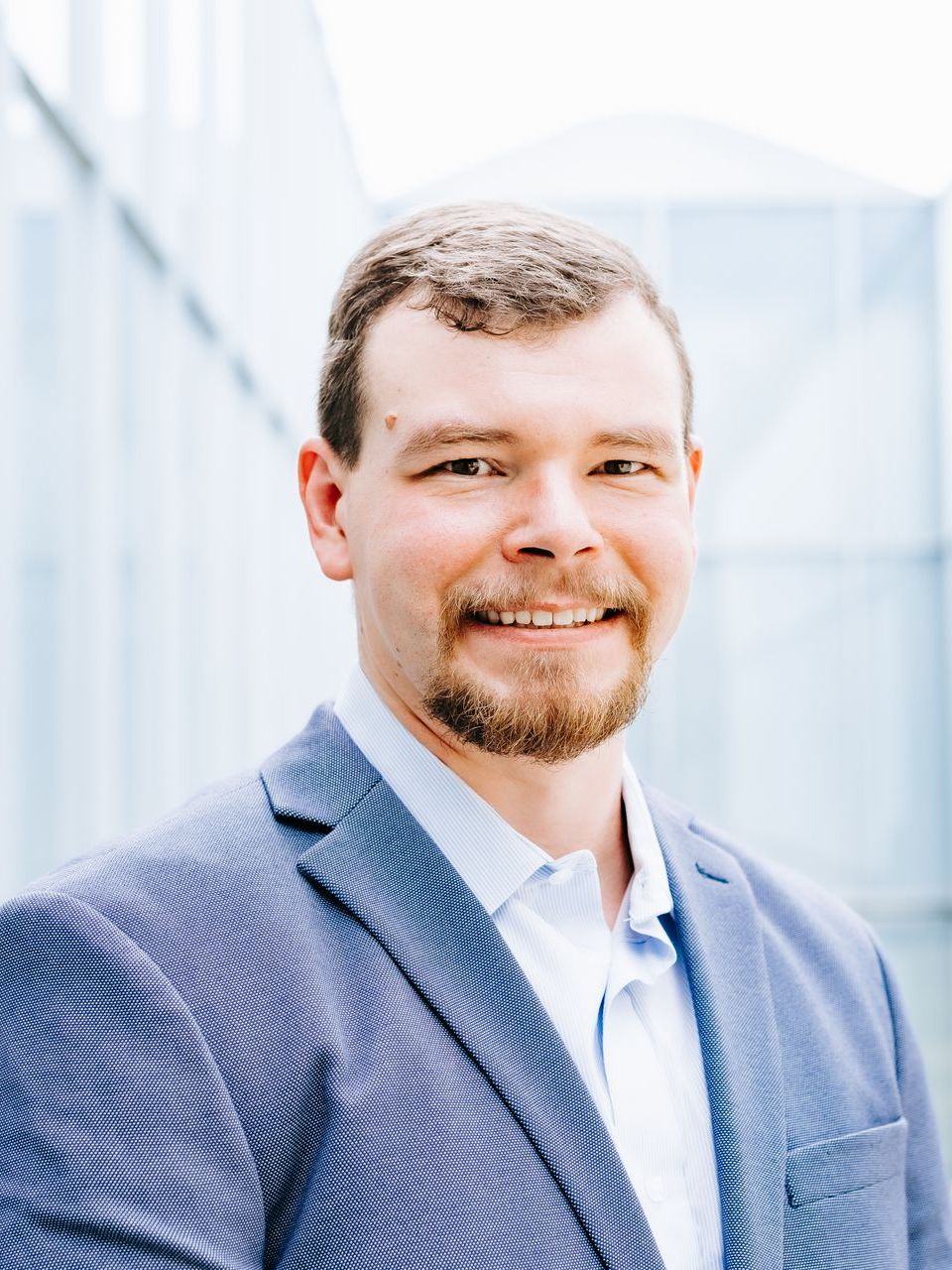 A man in a suit and tie is smiling for the camera.
