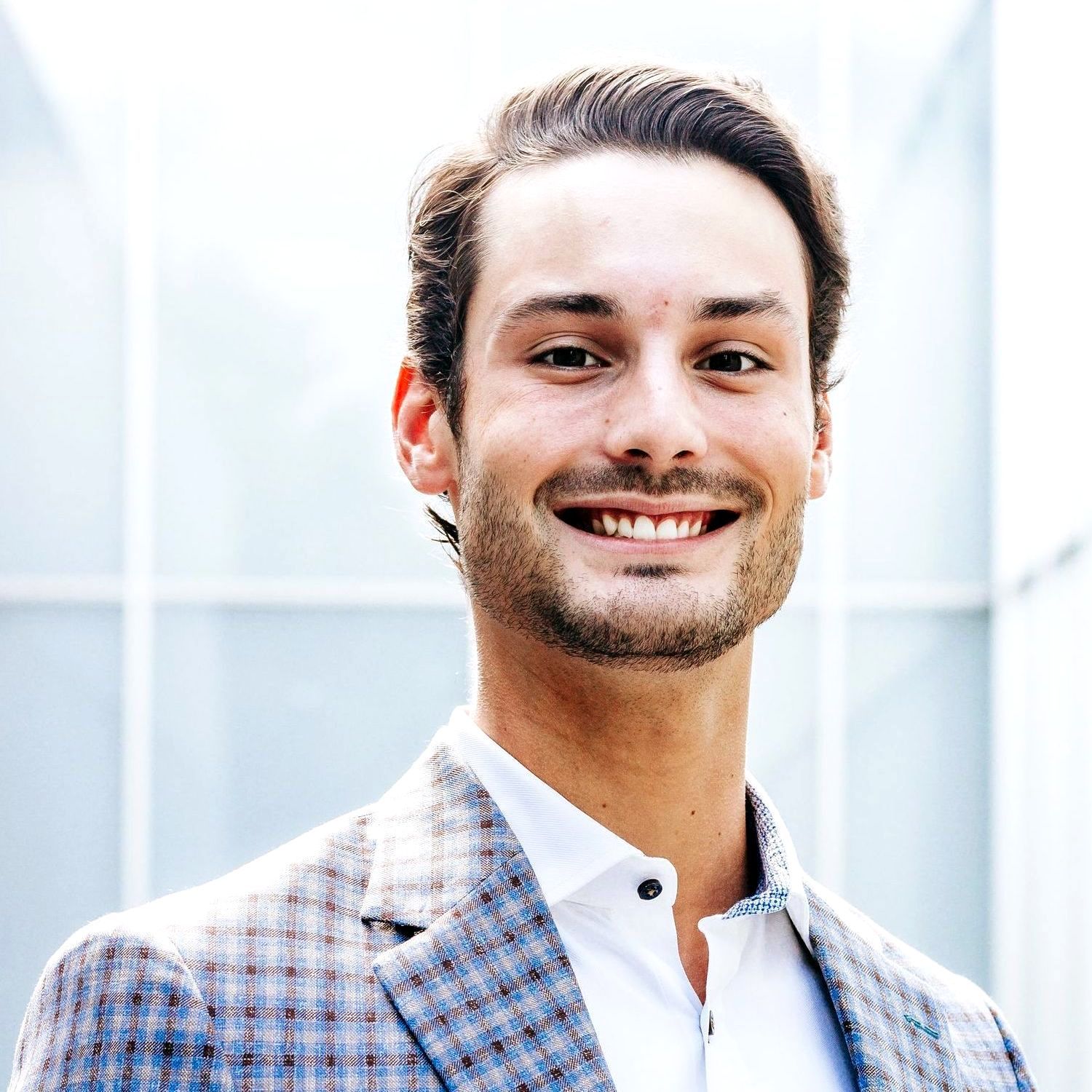 A man in a suit and white shirt is smiling for the camera.