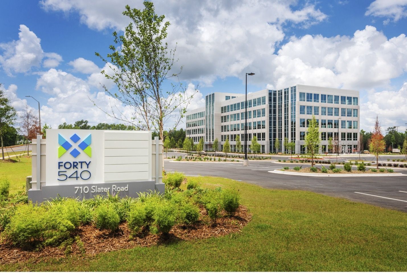A modern office building at Forty 540 with a branded entrance sign under a partly cloudy sky.