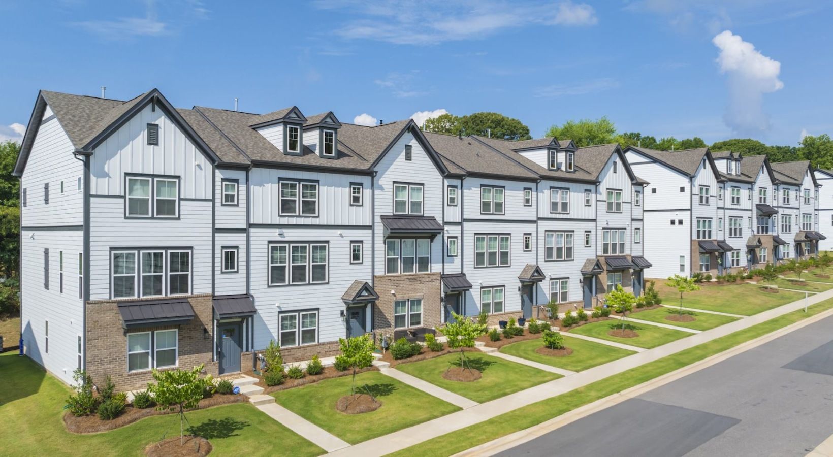 An aerial view of a row of apartment buildings on a sunny day.