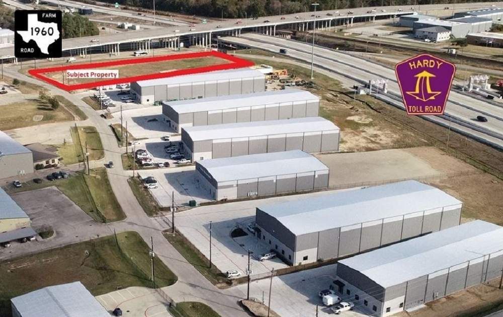 An aerial view of a warehouse area with a texas flag in the background