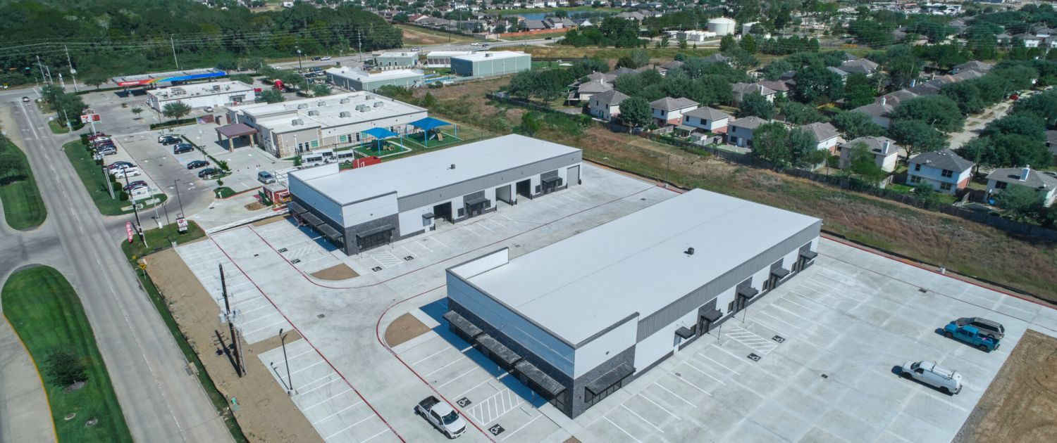 An aerial view of a large industrial area with buildings and a parking lot.