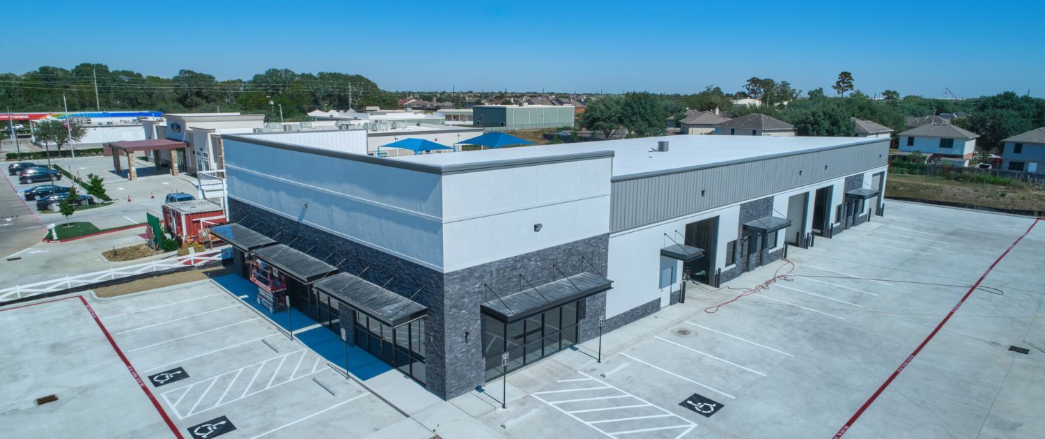 An aerial view of a large building with a parking lot in front of it.