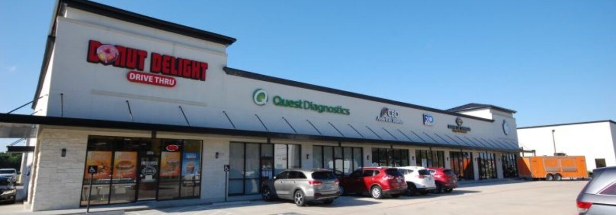 A store front with a lot of cars parked in front of it.