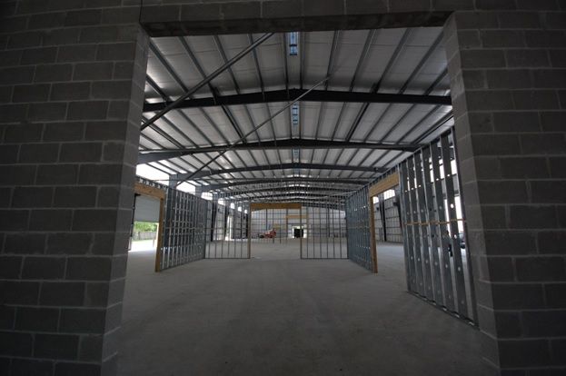 An empty building with a brick wall and a metal roof